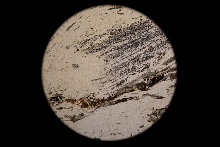 Circular microscopic image of rock structure.