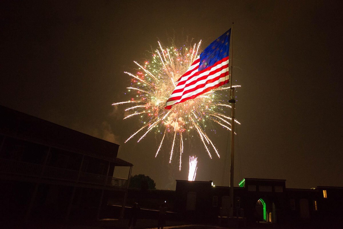 Fireworks light up a large 15-star US flag at Fort McHenry