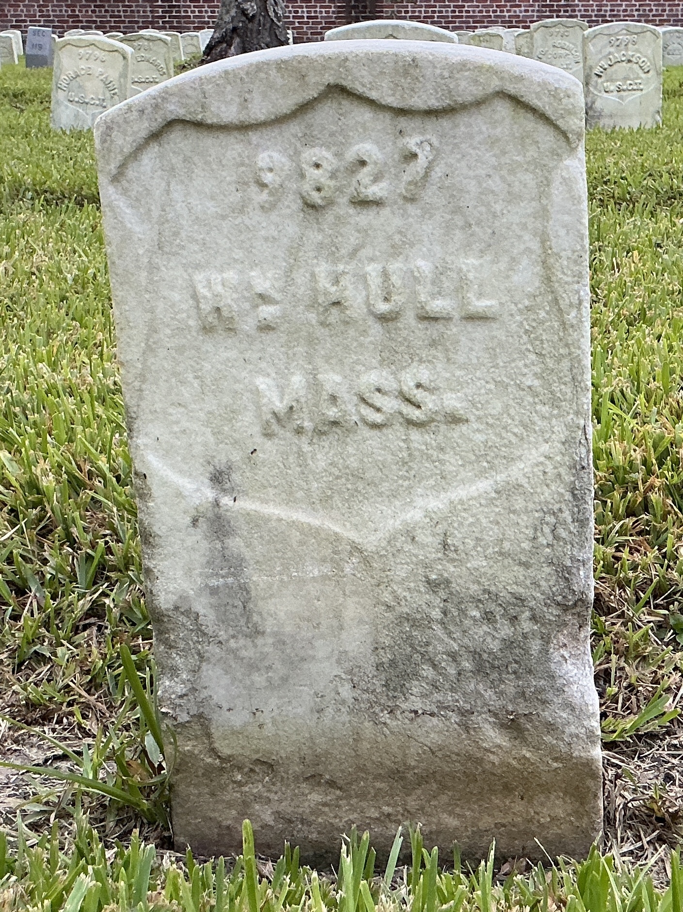 Front of historic upright marble headstone with recessed shield face.