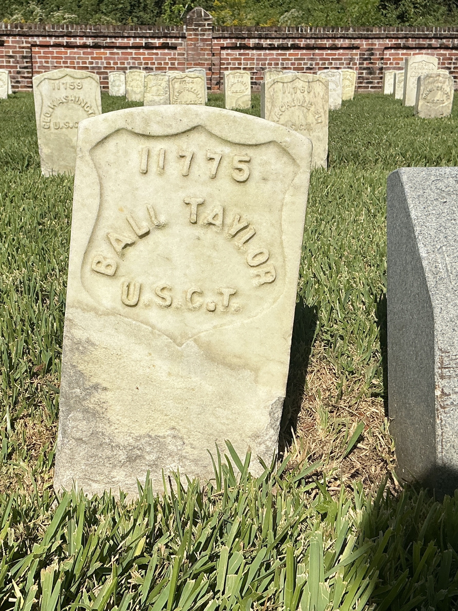 Front of historic upright marble headstone with recessed shield face.