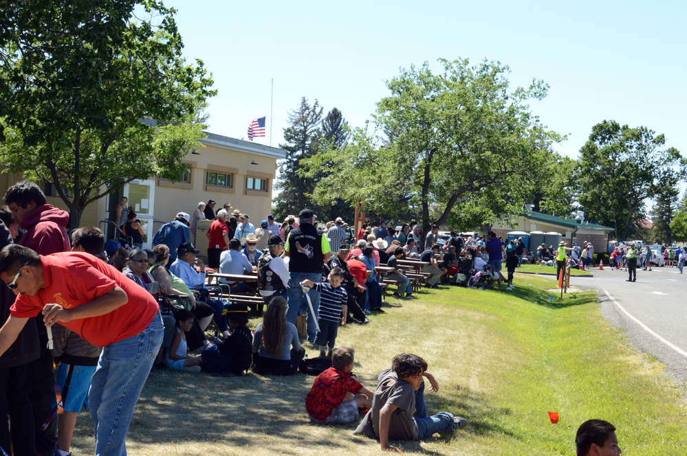 Visitors sitting on the grass waiting for riders 