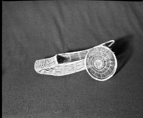 Marie Rozier Collection, Catalog No. 22. Object: Yurok/Karok/Hupa baby basket model. Dimensions: 17 x 6". Materials: Hazel shoots, beargrass, alder bark dyed-woodwardia, fern stem. Collection History: From Mrs. Long collection. Photographed by Michael Dixon in December 1982. Catalogued by Craig Bates and Barbara Beroza. Yosemite Collections, National Park Service.