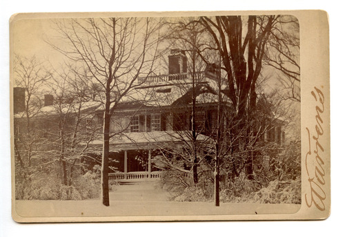Black and white photograph of Georgian mansion in the snow.