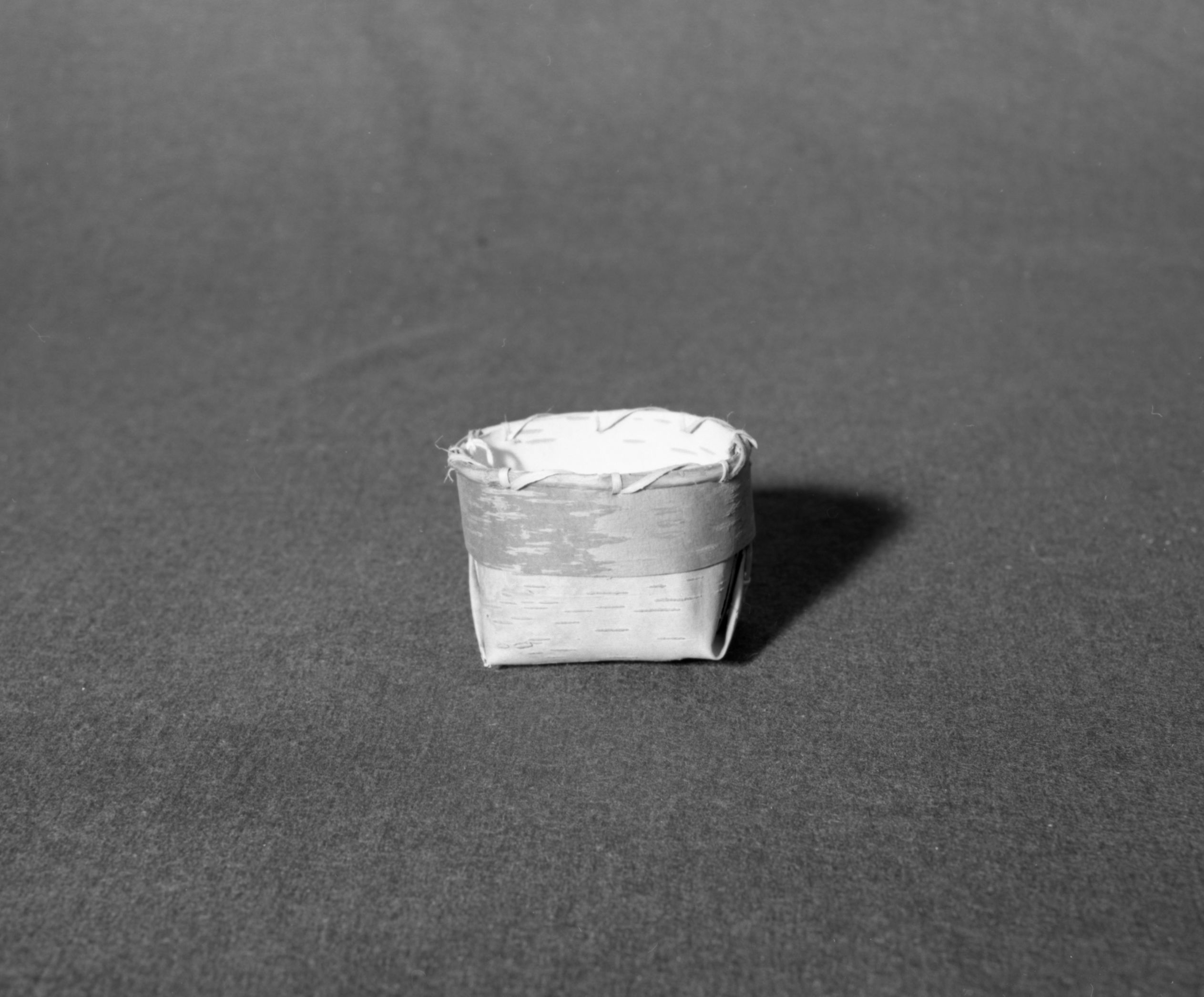 Marie Rozier Collection, Catalog No. 244. Object: Alaskan container. Dimensions: 3 1/2 x 3 x 2 1/2". Materials: birchbark, conifer root, split shoot. Collection History: Made for tourists, collected by M. Long in Kotzebue in 1972. Photographed by Michael Dixon, December 1982. Catalogued by Craig Bates and Barbara Beroza. Yosemite Collections, National Park Service.