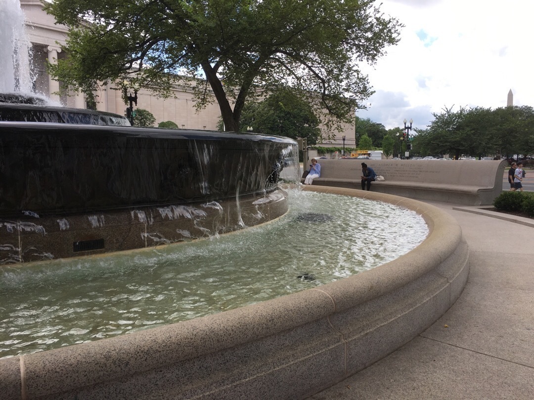 A circular fountain with a bench circling around it