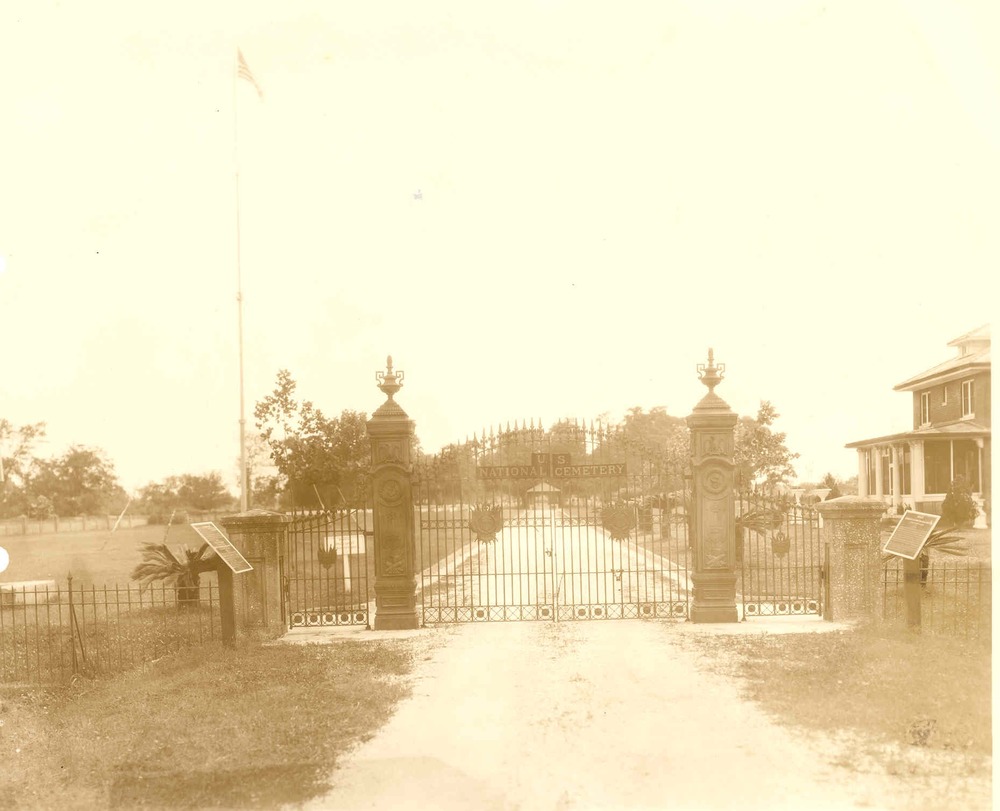Photo taken of iron gates at north entrance to Chalmette National Cemery in the early 20th century.