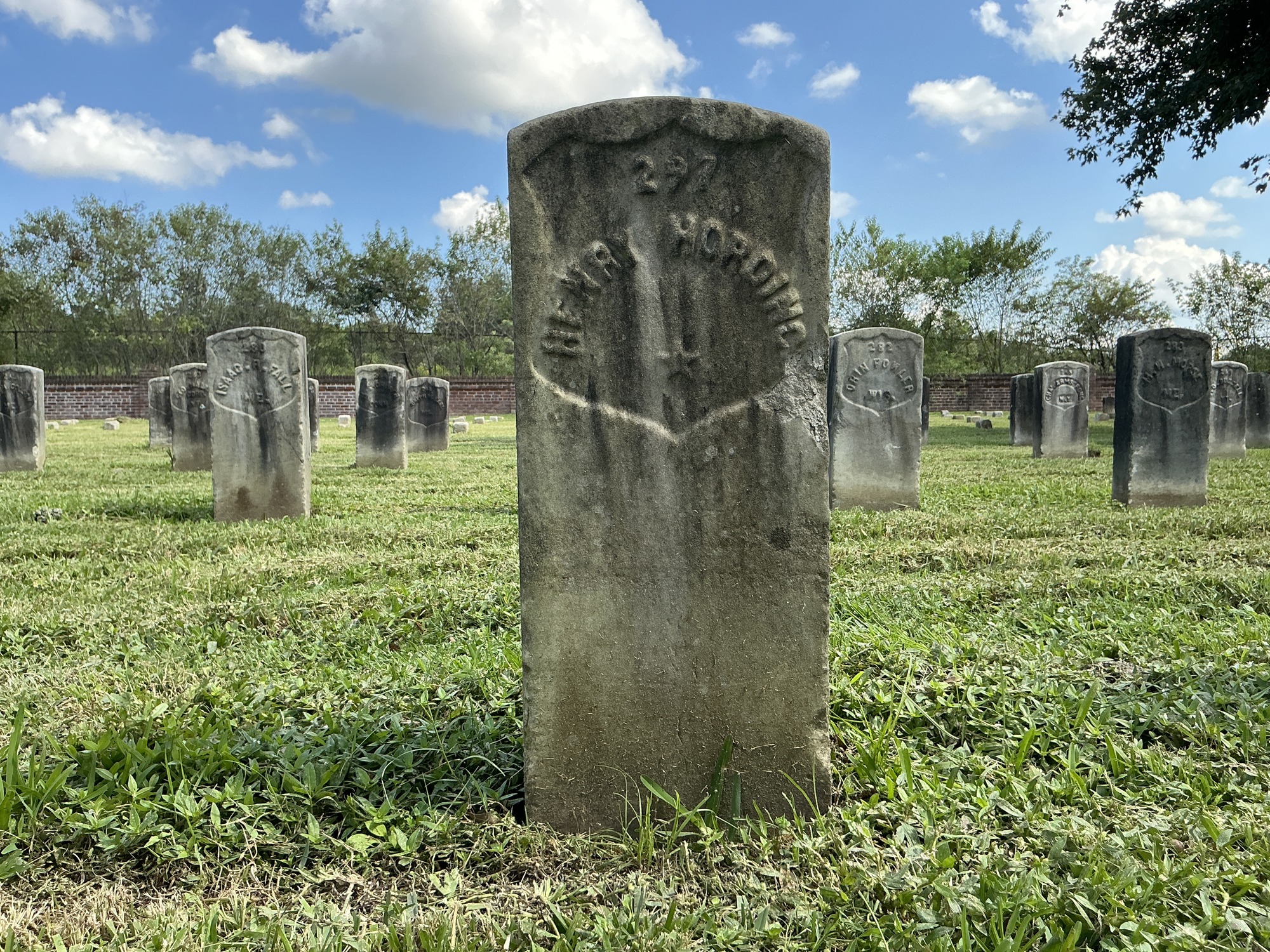 Front of historic upright marble headstone with recessed shield face.