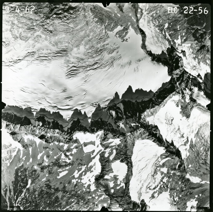 Black and white aerial photograph of glaciated mountain peaks and valleys.