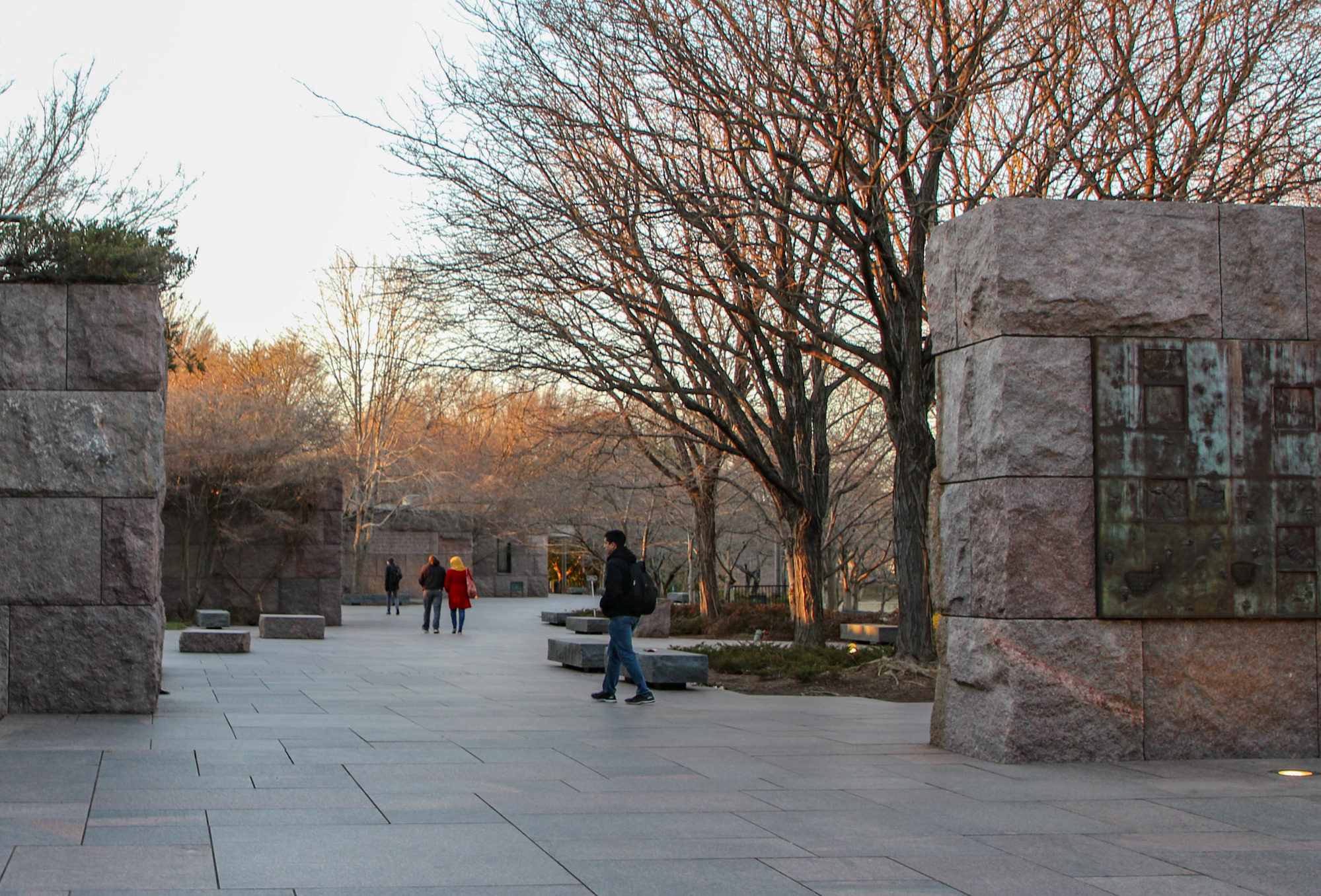 Visitors walking past stone walls 