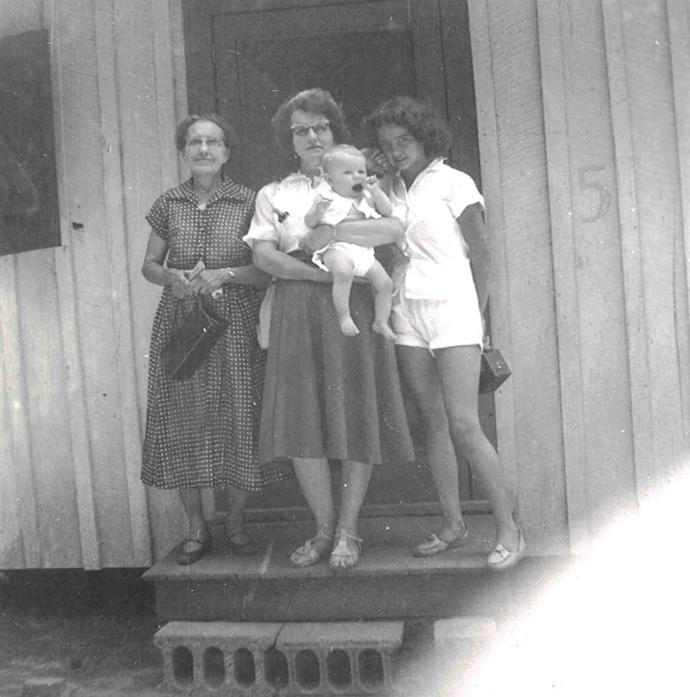 women posing on front steps of a cabin