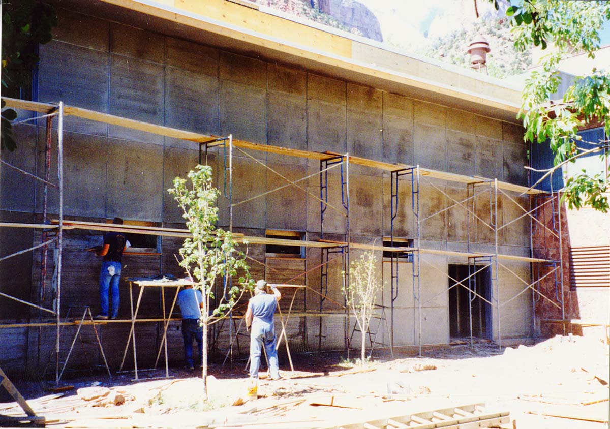 Men working on the outside wall during construction of headquarters addition.