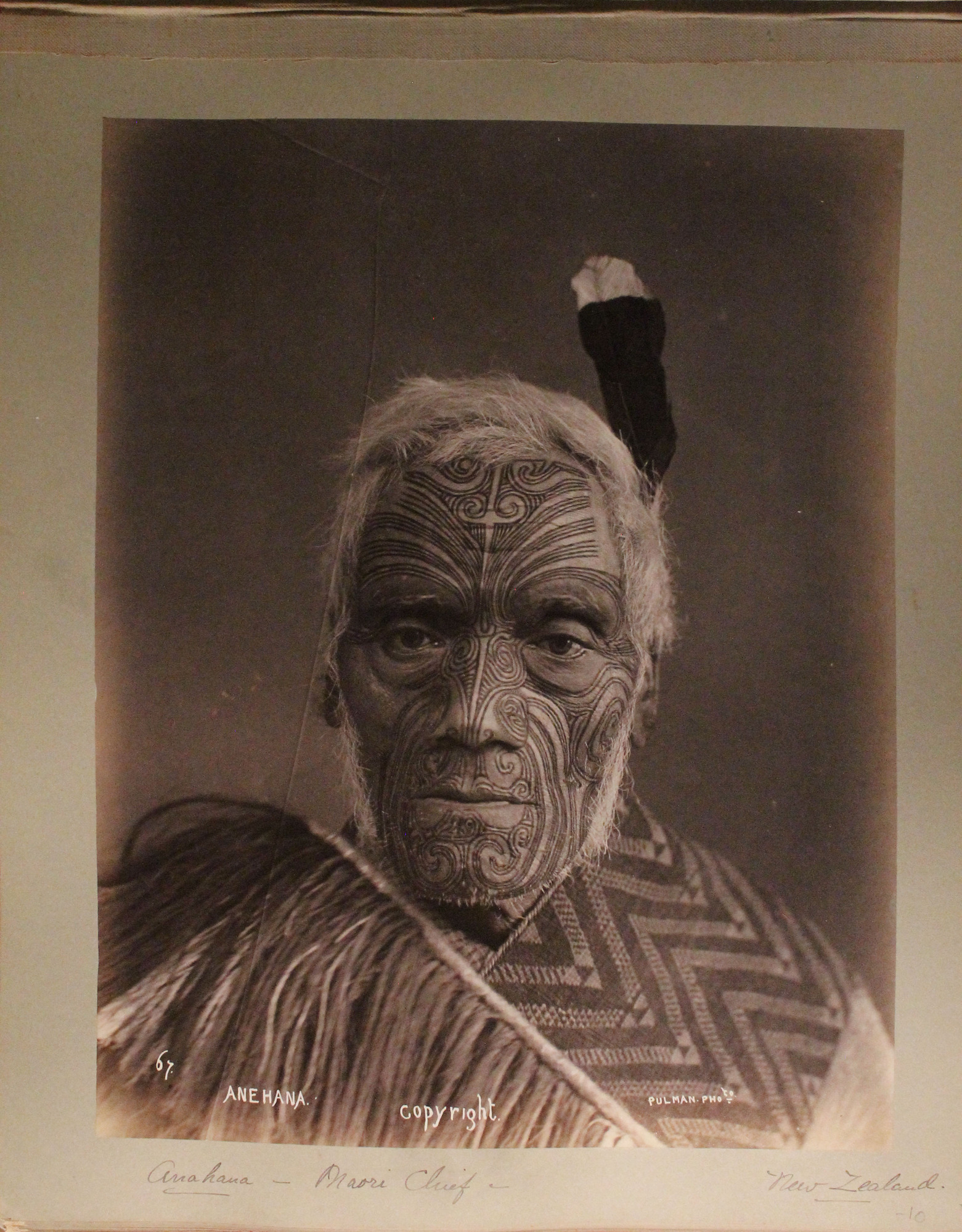 Maori chief in traditional face tattoos and attire.
