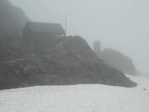 Rocky hills and small buildings in fog