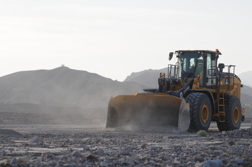 a large tractor moving gravel in a desert canyon