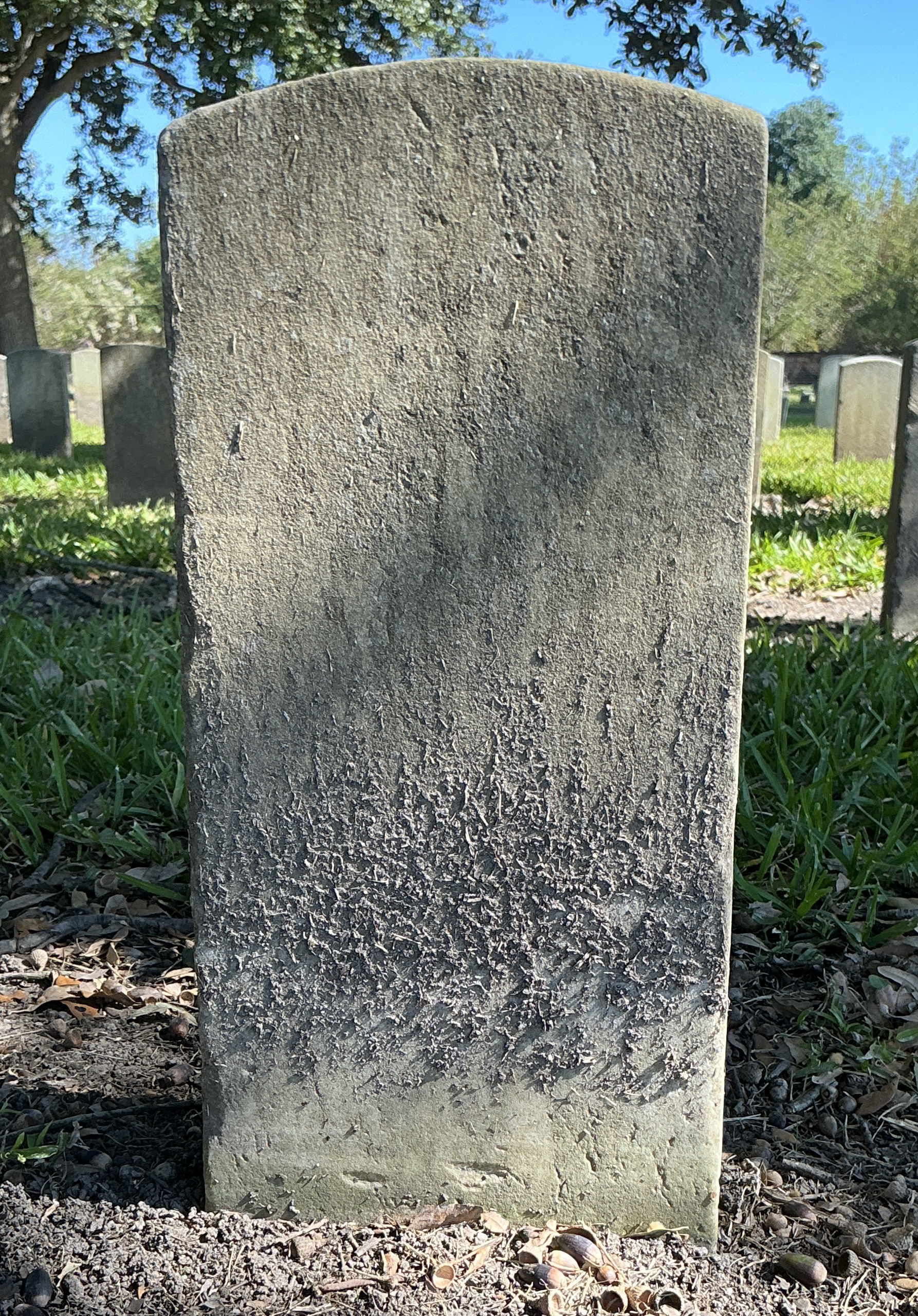 Back of historic upright marble headstone with recessed shield with recessed lettering face.