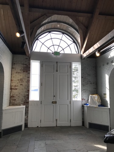 a round light above a doorway and wooden ceiling above