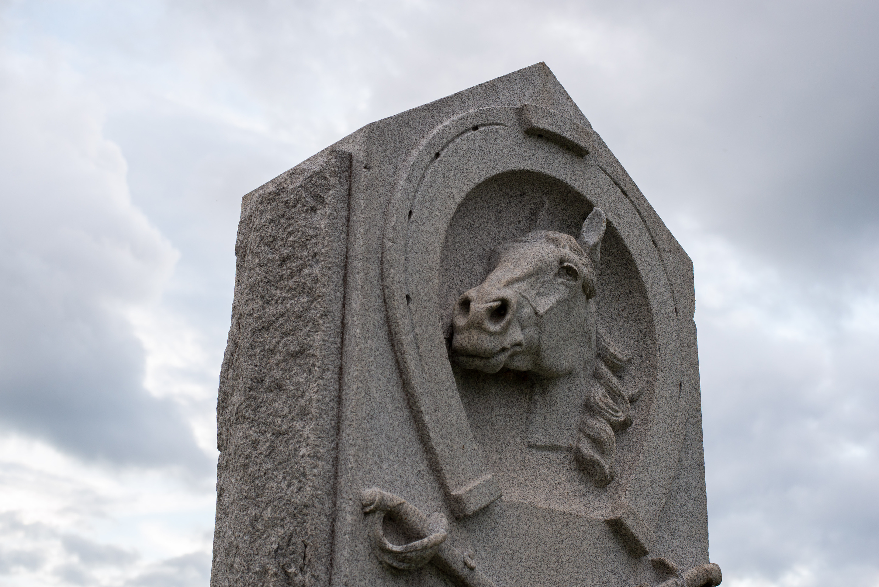 A close up of a monument with a stone carving of a horse.