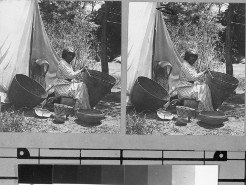 Indian Mary repairing burden basket. Indian Mary was Miwok. Here she replaces a rim stcik on a western Mono burden basket. The other baskets set about are from Boysen's collection.