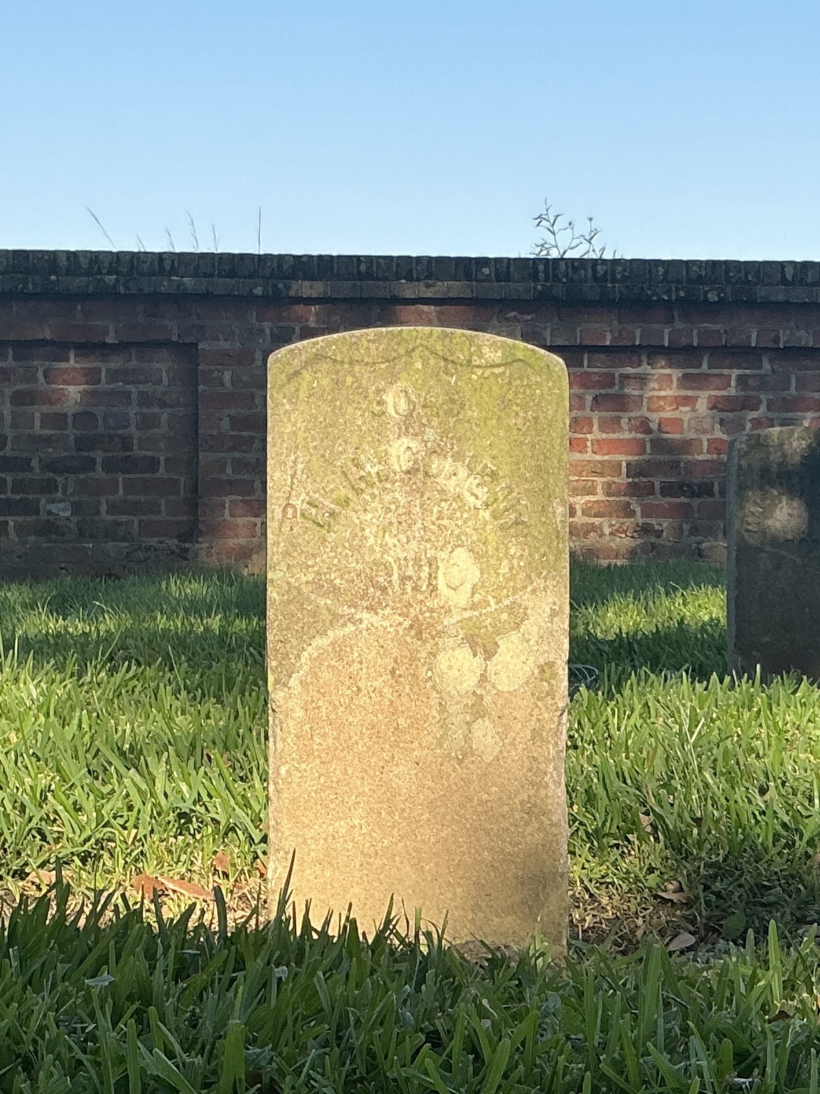 Front of historic upright marble headstone with recessed shield face.