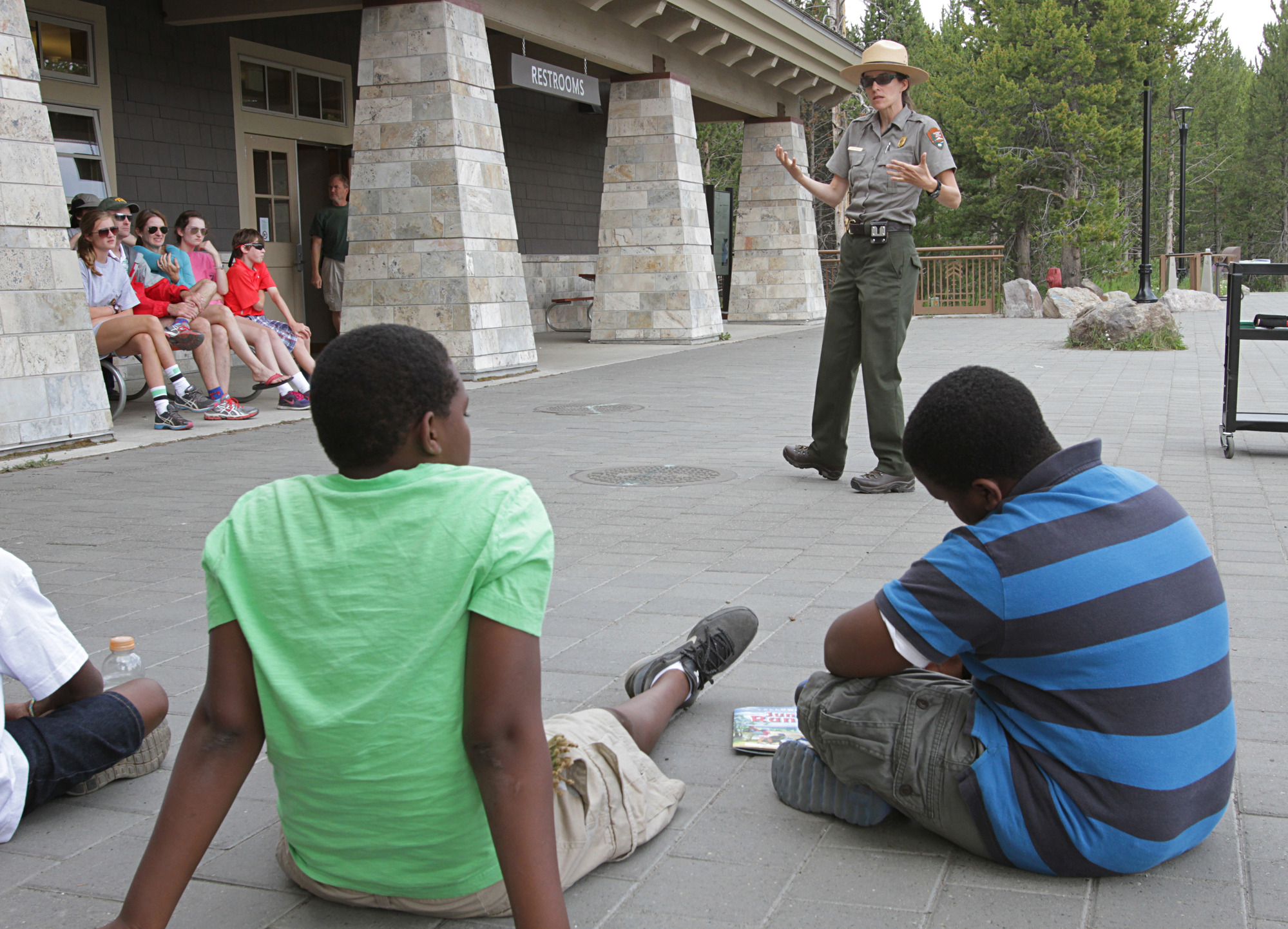 Ranger talks with seated group outside of a visitor center