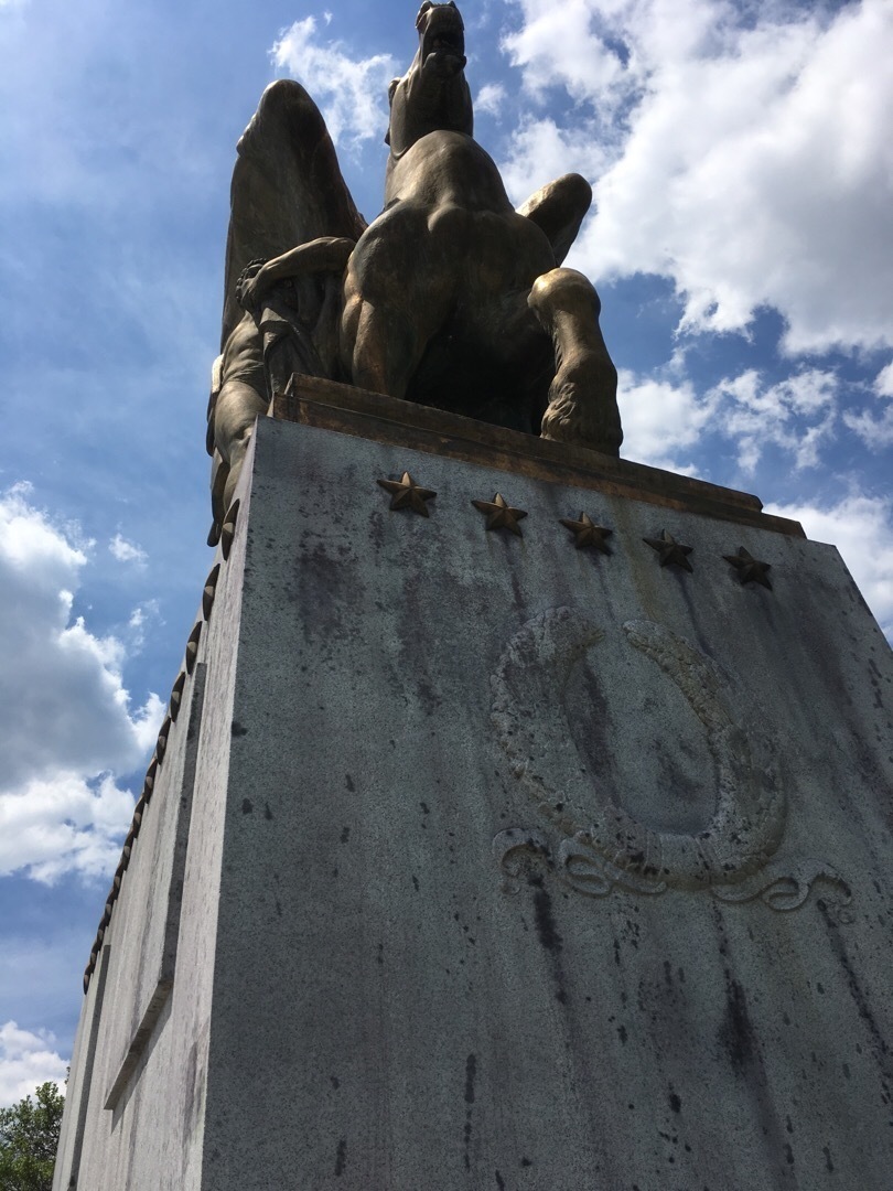 A statue of a horse on top of a stone pedestal