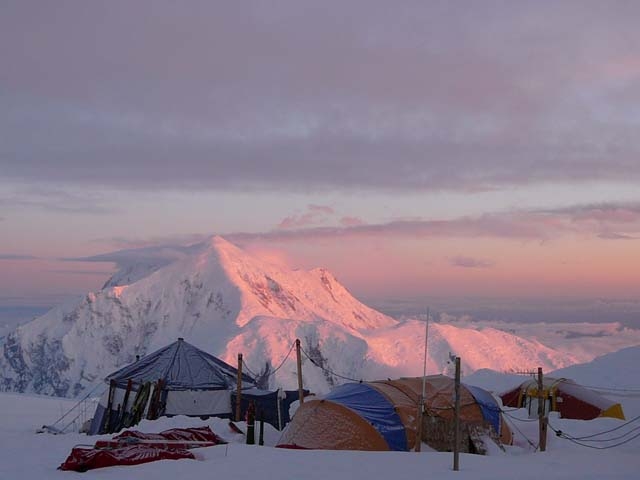 tents and a distant mountain, tinged pink