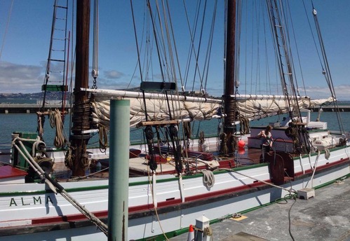 A woman using a mop on the deck of a boat.