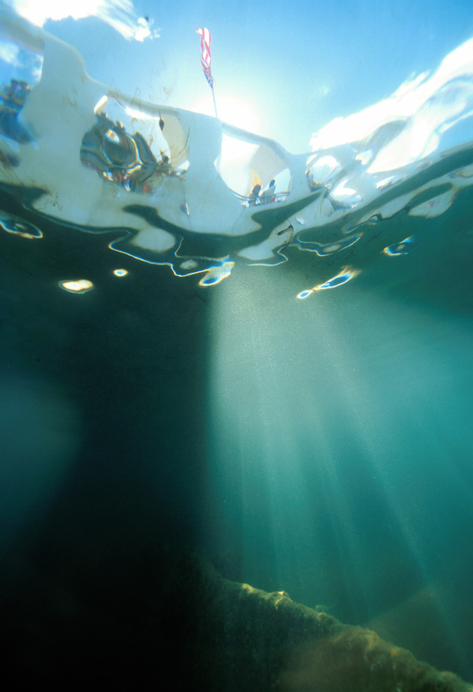 Looking up through the water to the Memorial from the deck of the ship, with sunlight streaming through the water.  