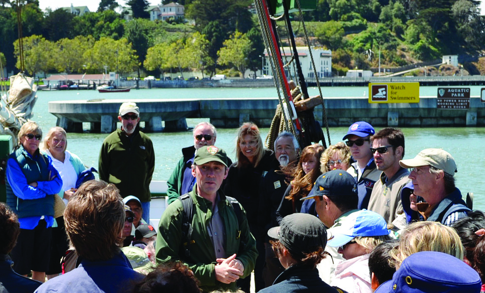 Park Ranger JR talking with visitors as they prepare to set sail on the Alma