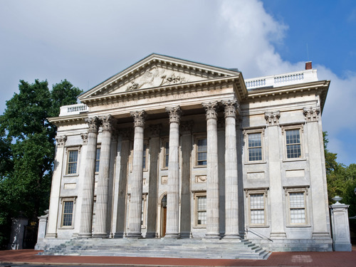 Color photo showing two-story marble building with multiple columns supporting triangular pediment.