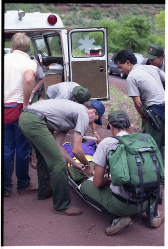 Color photo of SAR team transporting injured man.