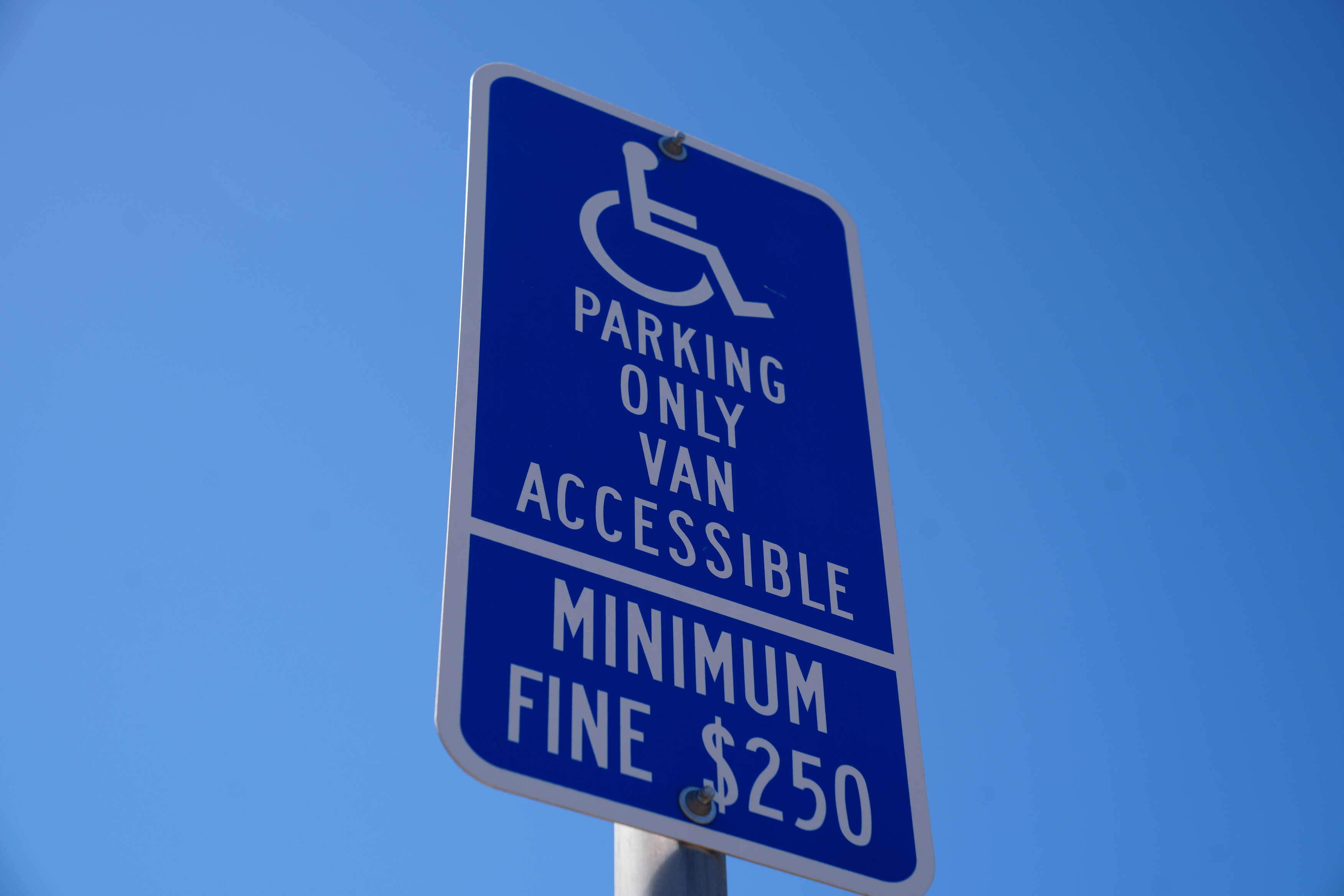 ADA parking sign with sky in the backgorund