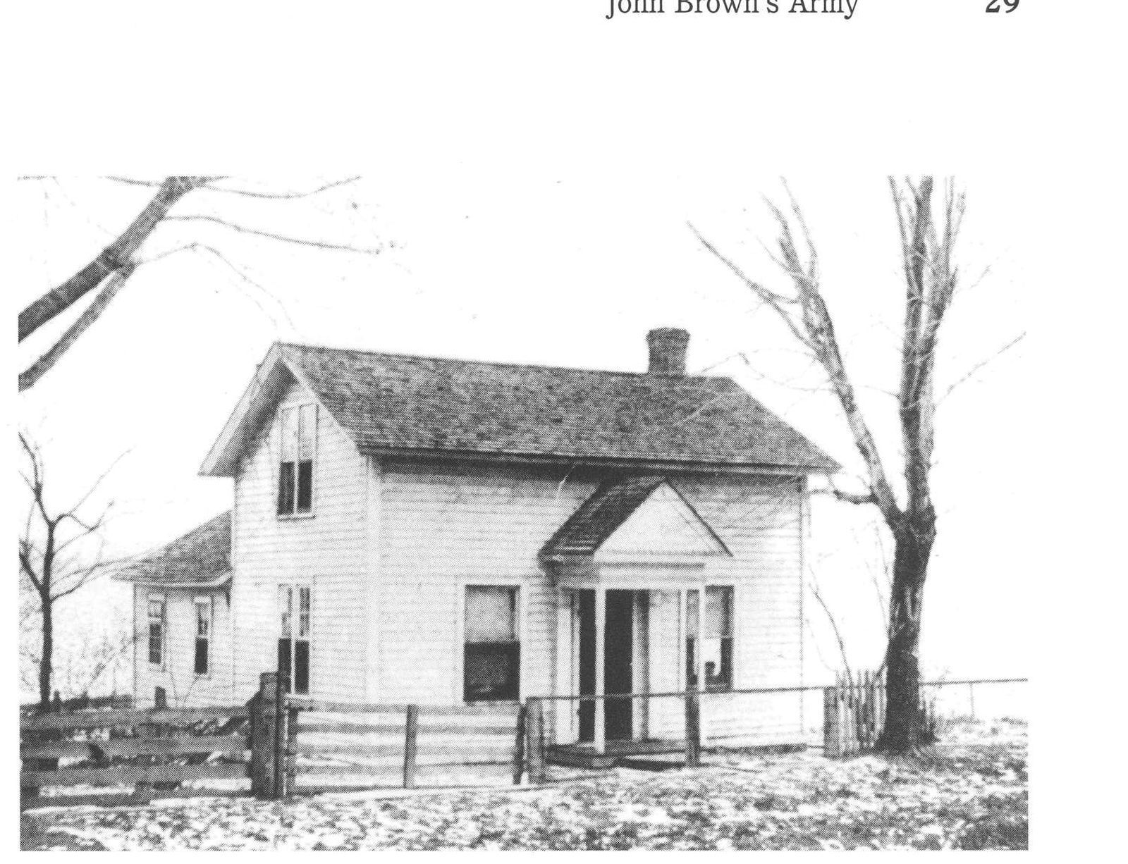 A white two story house with an awning over the front door with a tree next to the side of the house.
