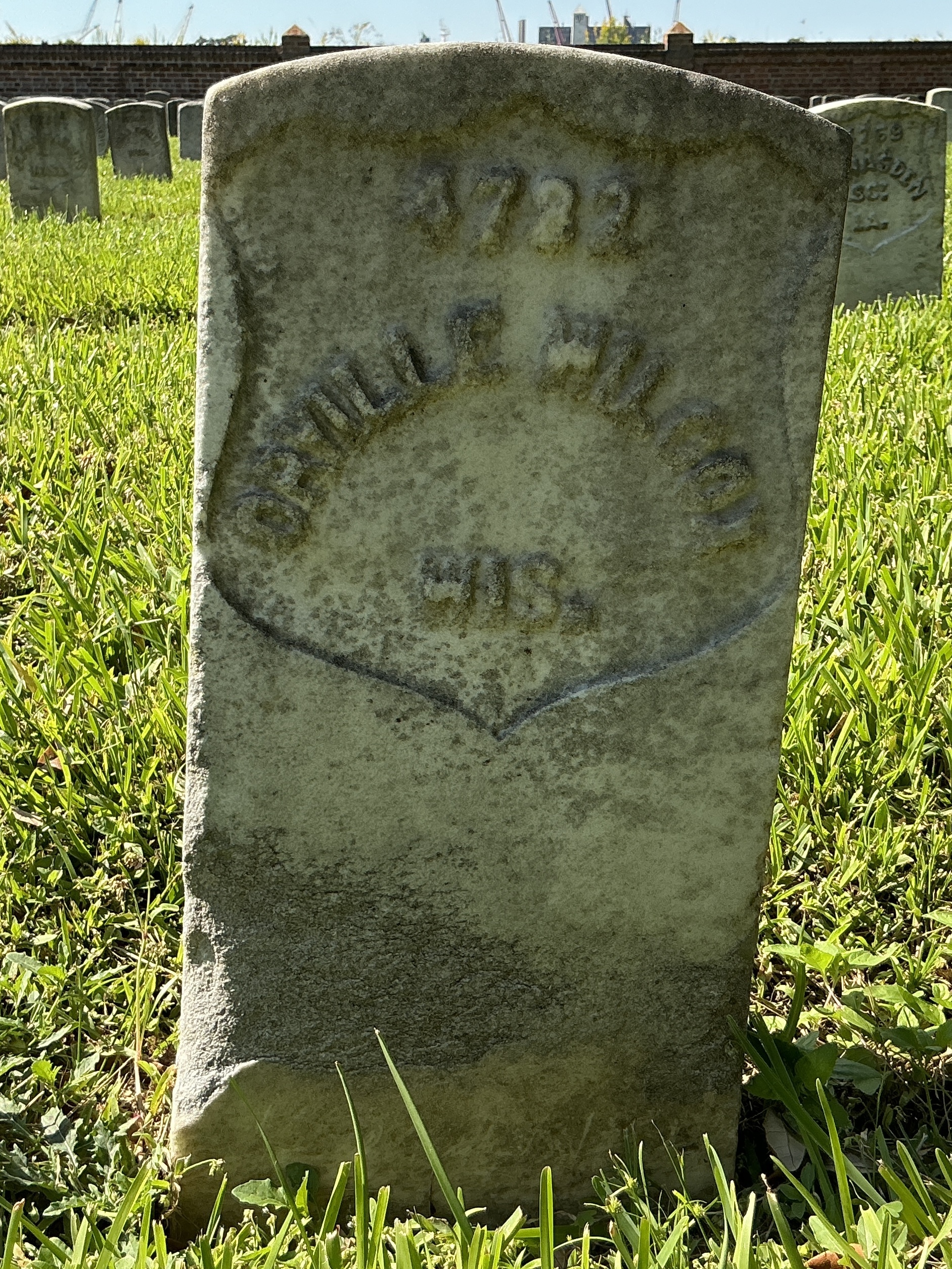 Front of historic upright marble headstone with recessed shield face.