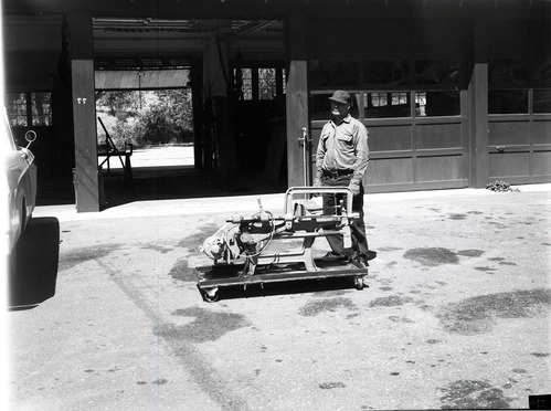 BW Photos of man standing next to maintenance equipment.