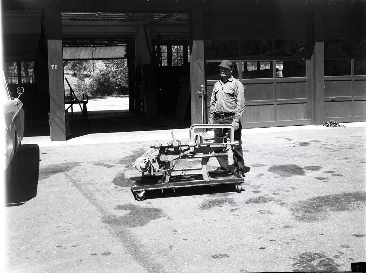 BW Photos of man standing next to maintenance equipment.