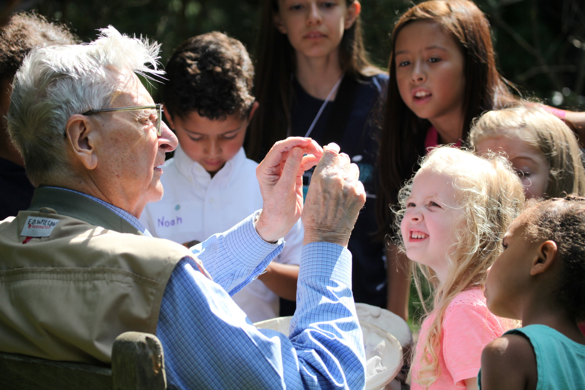An older man shows something unseen to young children