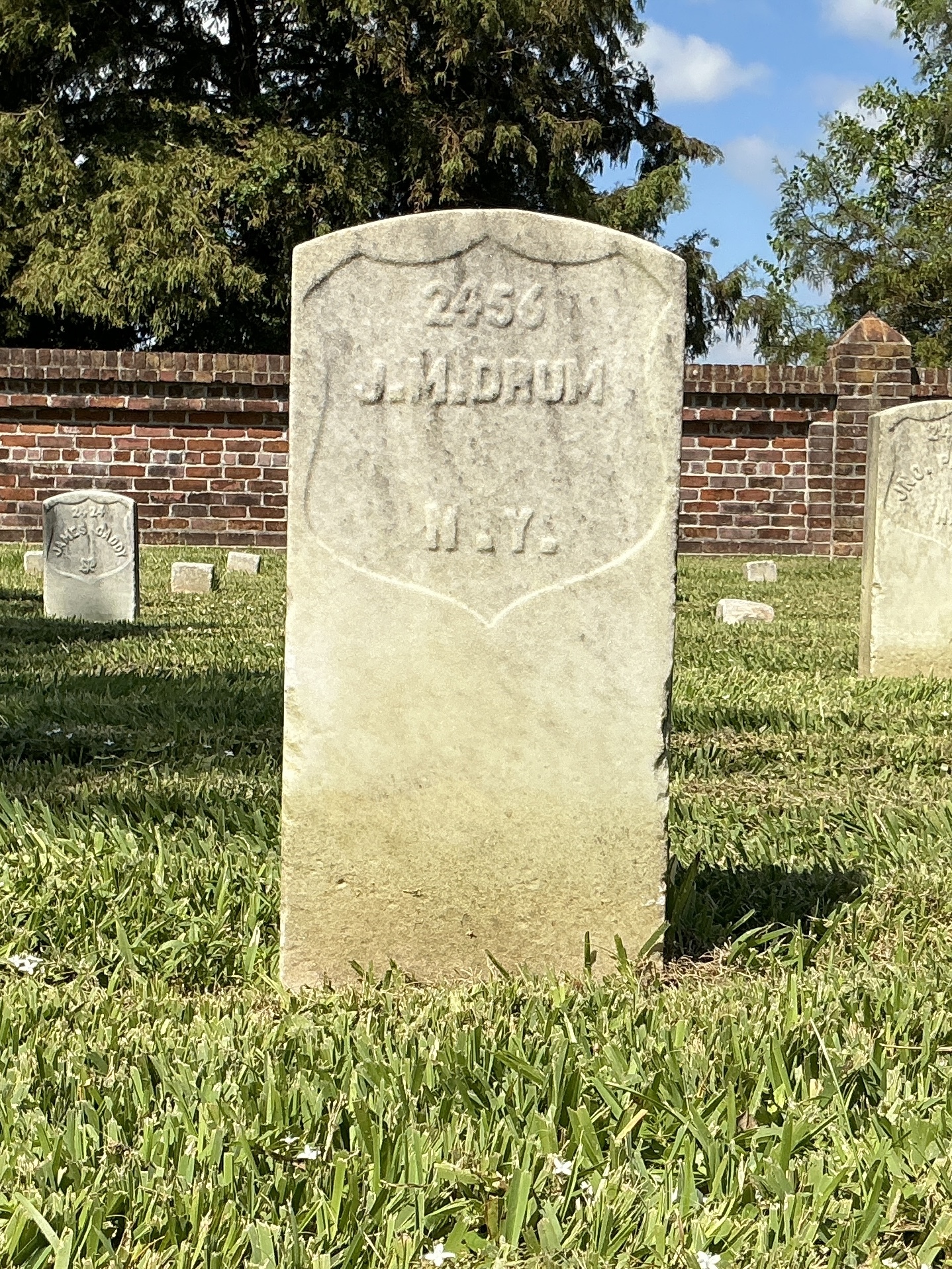 Front of historic upright marble headstone with recessed shield face.