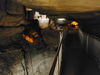 A metal bridge crosses a large pit in the cave. 