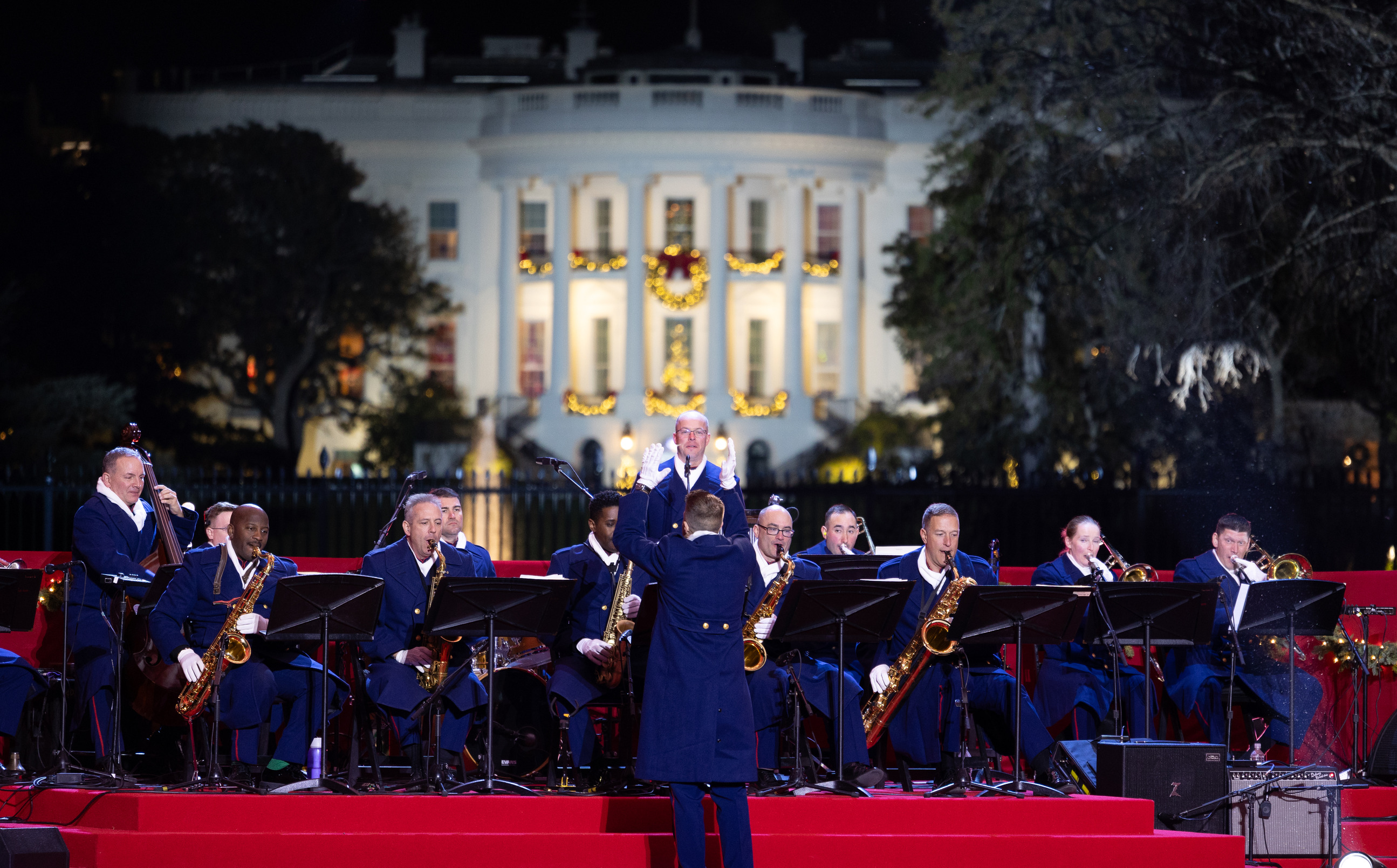 A band plays on a stage in front of the White House