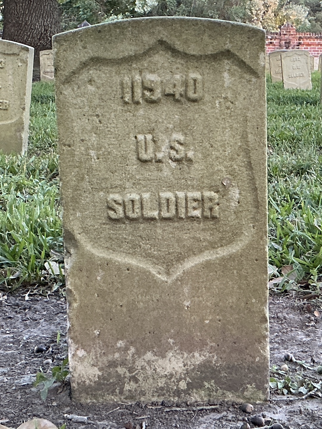 Front of historic upright marble headstone with recessed shield face.