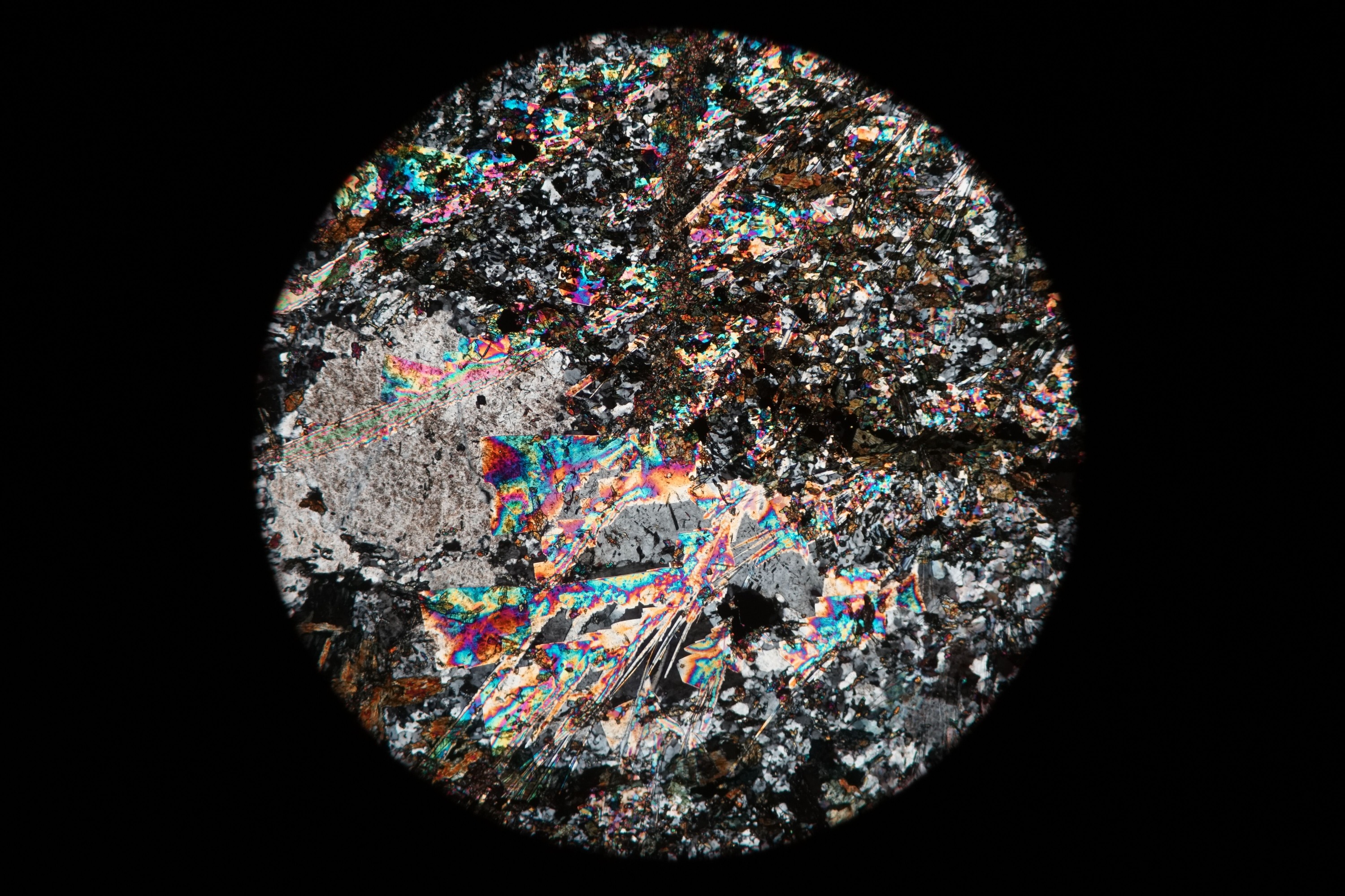 Circular microscopic image of rock structure.