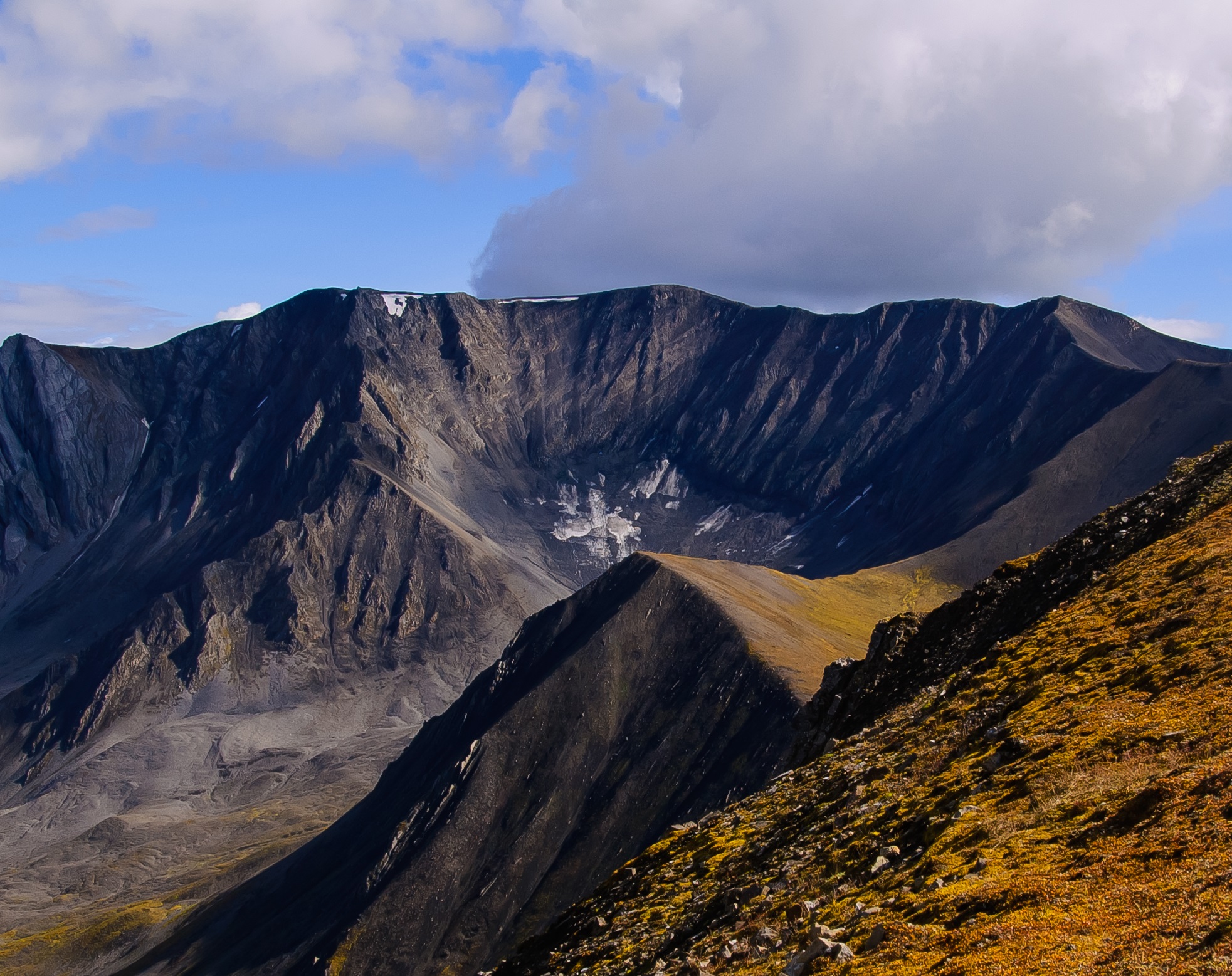 a wide view of a rocky mountain range with a bowl shaped valley