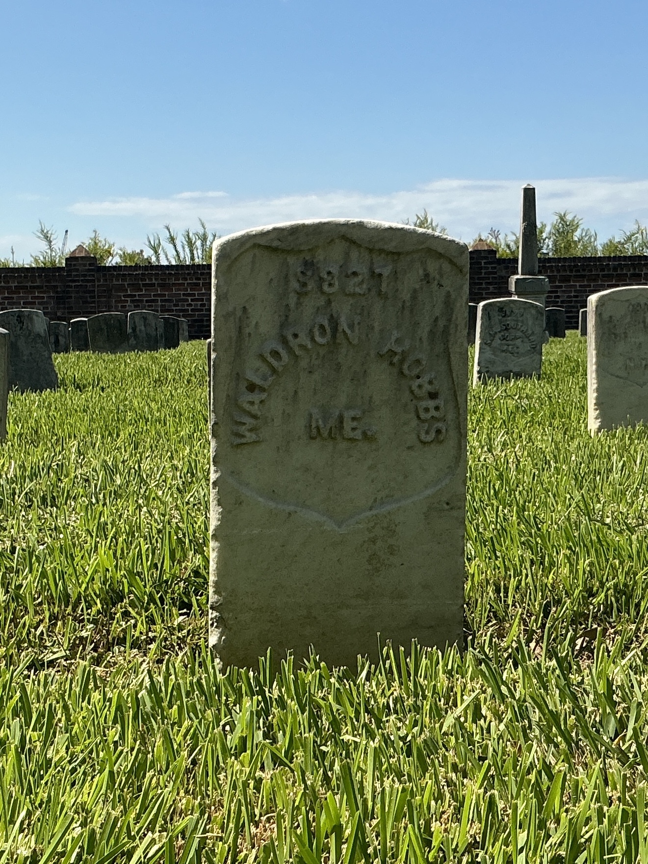 Front of historic upright marble headstone with recessed shield face.