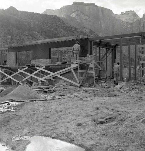 Two workers 'laying up' split blocks for visitor center wall during the Mission 66 Visitor Center and Museum construction.