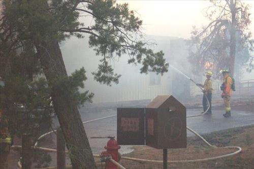 Firefighters battle flames in structures during the Long Mesa Fire, Mesa Verde National Park, July-August 2002