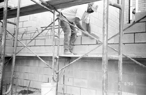Man worker laying bricks during the construction of headquarters addition.