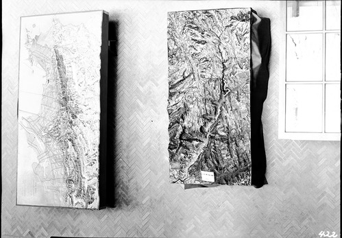 Telephoto from the third floor of the University of California Berkeley Hearst Memorial Mining Building, showing Zion National Park map and Berkeley Hills map. Herringbone-patterned brick flooring.