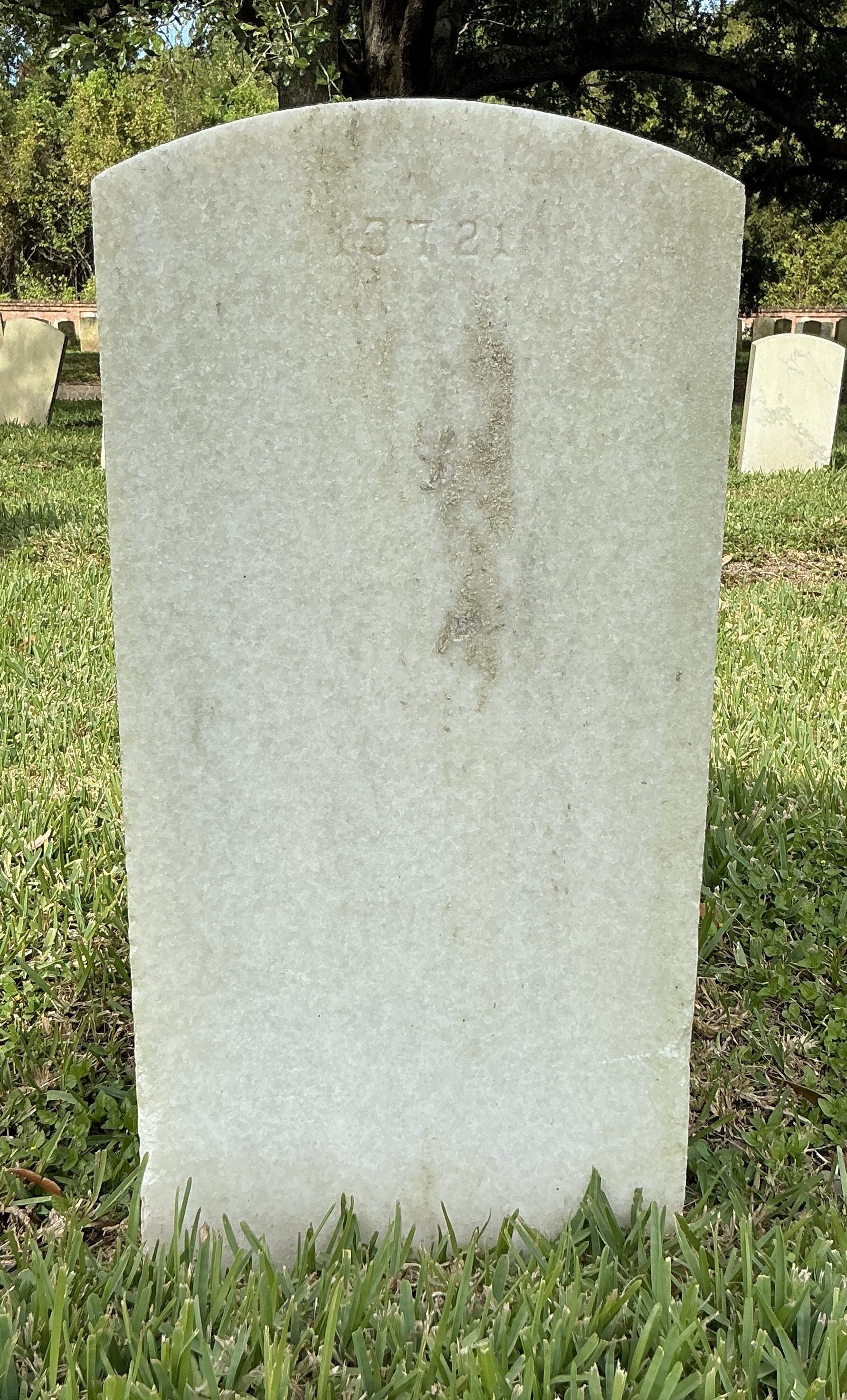 Back of upright marble headstone with flat face.