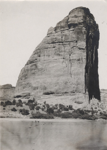 A 1909 expedition boat floats down river with Steamboat Rock in the background